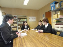 課長(中央)と商品発注会議をする皆さん