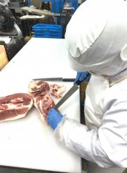 豚肉の加工をする女性スタッフ